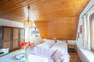 een slaapkamer met een bed en een houten plafond bij Zum Torkelhaus in Sipplingen