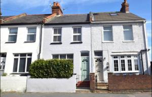 a white house with a green door at A lovely Three bedroom house in Windsor in Windsor