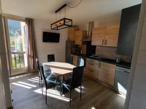 uma cozinha com mesa e cadeiras num quarto em location Appartement Bonascre toutes saisons em Ax-les-Thermes
