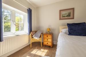 1 dormitorio con 1 cama, 1 silla y 1 ventana en The Mews en Goudhurst