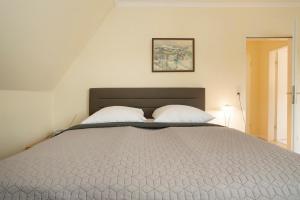 a bedroom with a large bed with two pillows at Haus Seepferdchen am Meer Appartement 7 in Timmendorfer Strand