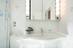 a white bathroom with a sink and a mirror at Haus Seepferdchen am Meer Appartement 7 in Timmendorfer Strand