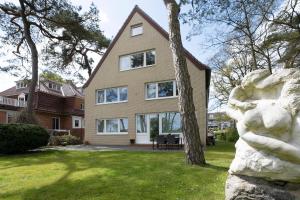 a large house with a tree in the yard at Haus Seepferdchen am Meer Appartement 7 in Timmendorfer Strand