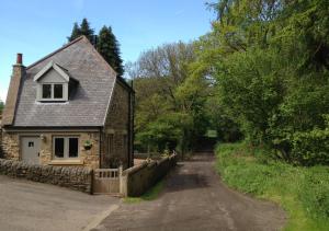 a stone house with a fence next to a road at The Old Paper Mill in Lintz Green