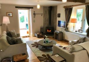 a living room with a couch and a table and a fireplace at The Old Paper Mill in Lintz Green