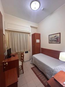 a hotel room with a bed and a desk and a computer at Il Nocchiero City Hotel in Soverato Marina