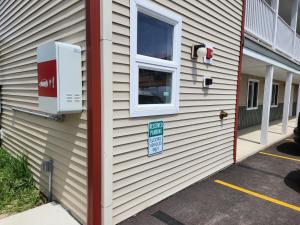 a house with a window and a sign on it at Driftwood Motel in Niagara Falls