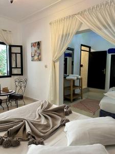 een slaapkamer met een bed en een kamer met een tafel bij El Kennaria in Marrakesh