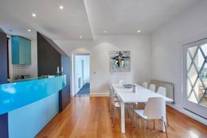uma cozinha e sala de jantar com uma mesa branca e cadeiras em Large Two Bedroom Apartment with City Park and Bay views em Melbourne