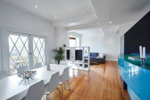 uma sala de jantar com uma mesa branca e cadeiras em Large Two Bedroom Apartment with City Park and Bay views em Melbourne