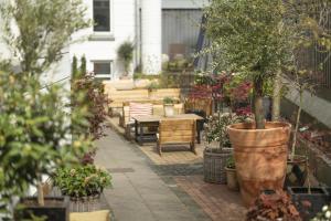 een patio met tafels en stoelen en potplanten bij Hotel Mayfair in Kopenhagen