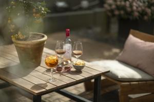 a wooden table with two glasses of wine and a bottle at Hotel Mayfair in Copenhagen