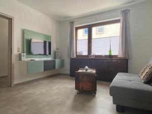 a living room with a couch and a television at Ferienwohnung Junglen an der Mosel in Zeltingen-Rachtig