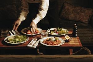 a person sitting at a table with plates of food at Parkhotel Mondschein, a Member of Design Hotels in Bolzano