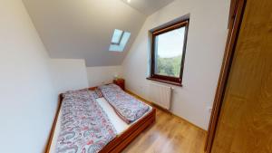 a small bedroom with a bed and a window at Kaszubdomki in Żukówko