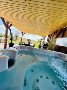 an outdoor hot tub with a wooden roof at L'échappée Belle by J&J Durbuy Area in Clavier
