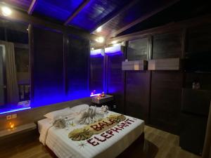 ジンバランにあるバリ エレファント ブティック ヴィラの青い照明が付いたベッドが備わる客室です。