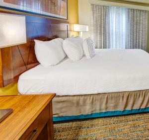 a hotel room with a bed with white pillows at Residence Inn by Marriott Memphis Southaven in Southaven