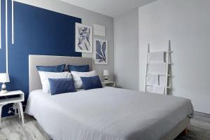 ein Schlafzimmer mit einem großen Bett mit blauen Wänden in der Unterkunft Appartement T4 centre-ville, plage à 5 min à pied in Sainte-Maxime