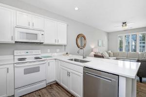 a kitchen with white cabinets and a sink at A Sandy Situation in Myrtle Beach