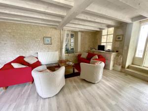 un soggiorno con divani rossi e sedie bianche di Maison de 3 chambres avec jardin clos et wifi a Saint Palais du Ne 
