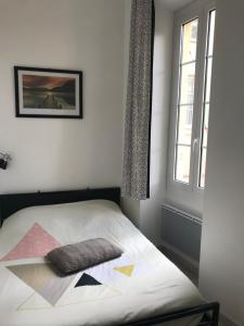 a bedroom with a bed with a pillow on it at appartement Menton au coeur de la vieille ville in Menton