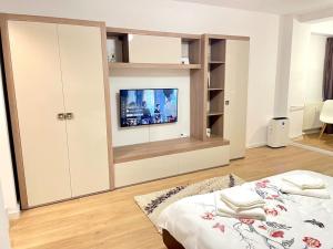 a bedroom with a bed and a tv on a wall at Studio Dristor - foarte curat si frumos in Bucharest