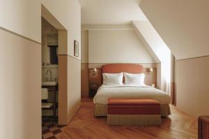 a bedroom with a large bed and a kitchen at Parkhotel Mondschein, a Member of Design Hotels in Bolzano