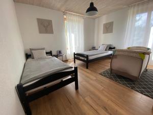 two beds in a room with wooden floors and windows at Hostellerie des Princes-Evêques - La Fleur de Lys in Porrentruy