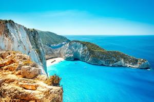 a view of a beach with blue water and a cliff at Villa Roxa Montuoso in Agios Leon