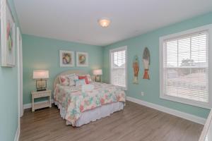 Schlafzimmer mit blauen Wänden und einem Bett mit Kissen in der Unterkunft Beach Retreat in Myrtle Beach