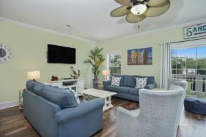 a living room with blue couches and a tv at Sun Sational in Myrtle Beach