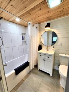 y baño con bañera, lavabo y aseo. en Exclusive 2 Chalet Stay-HotTub-Fireplace-Beachside, en Traverse City