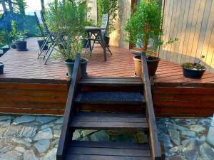 a wooden deck with a staircase with potted plants at Apartmány Kocanda in Jesenice