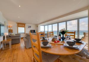 a dining room with a table and chairs with the ocean at Carthew House Carthew Way in St Ives