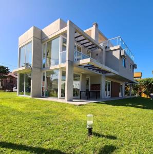 una casa grande con césped delante en Complejo 42 en Balneario Mar Azul