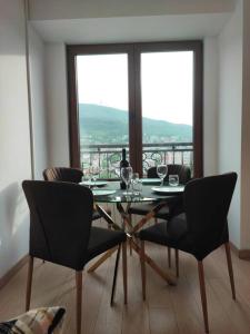 een eetkamer met een tafel en stoelen met uitzicht bij Grand View Apartment in Skopje