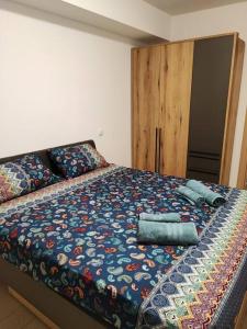 een bed met een kleurrijk dekbed en kussens erop bij Grand View Apartment in Skopje