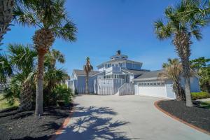 a house with palm trees in front of a driveway at Seascape in Myrtle Beach
