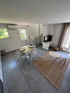 a living room with a table and chairs and a tv at La Villa Rapha'elle in Saint-Raphaël
