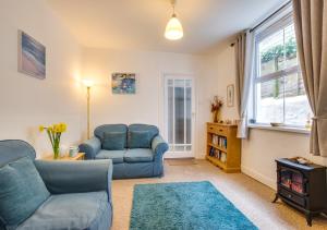 a living room with a couch and chairs and a stove at An Marghty 4a Carthew Terrace in St Ives