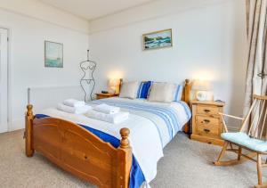 a bedroom with a wooden bed with a blue chair at An Marghty 4a Carthew Terrace in St Ives