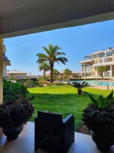 balcón con vistas a un patio con palmeras en Appartement-résidence prestigia plage des Nations, en Rabat