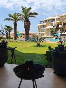 una hoguera en un patio con palmeras y un edificio en Appartement-résidence prestigia plage des Nations, en Rabat