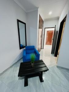 uma sala de estar com uma cadeira azul e uma mesa em Maun Nest Hotel em Maun