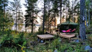 una tienda en el bosque con mesa y sillas en Club House Hotelli Kaipolan Ranta en Jämsä