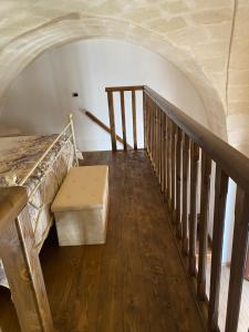 a room with a bed and a staircase with a bench at Casa Muscettola in Leporano