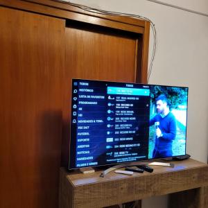 een flatscreen-tv zittend op een tafel bij Residencial com CHURRASQUElRA! in Bento Gonçalves