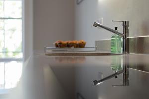 a kitchen counter with a sink and a faucet at Luxury flat next to town centre Long-stay discount in Reading +20 photos