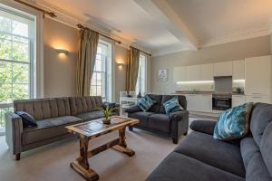 a living room with two couches and a table at Luxury flat next to town centre Long-stay discount in Reading